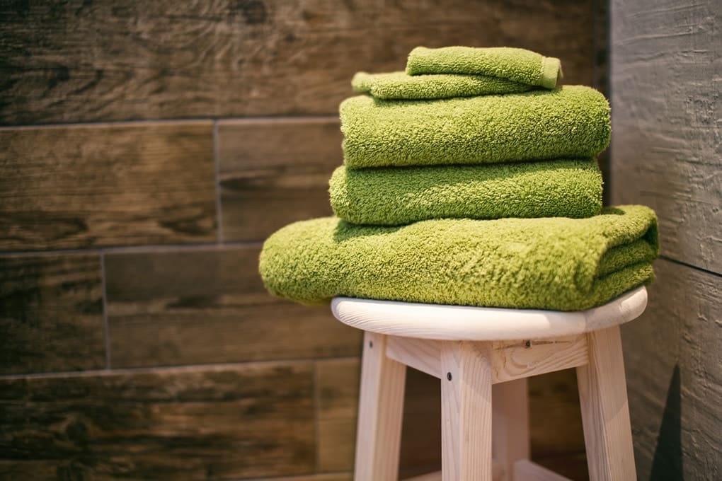 5 green towels on top of a stool